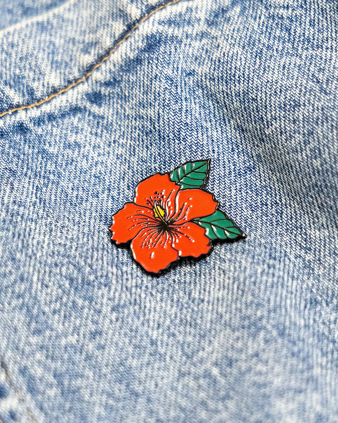 pink hibiscus flower pin on a denim background inspired by sudanese culture on a brown bag as part of islamic relief uk new sudan souq collection