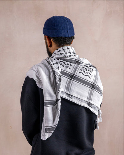 a man wearing the palestinian black and white keffiyeh