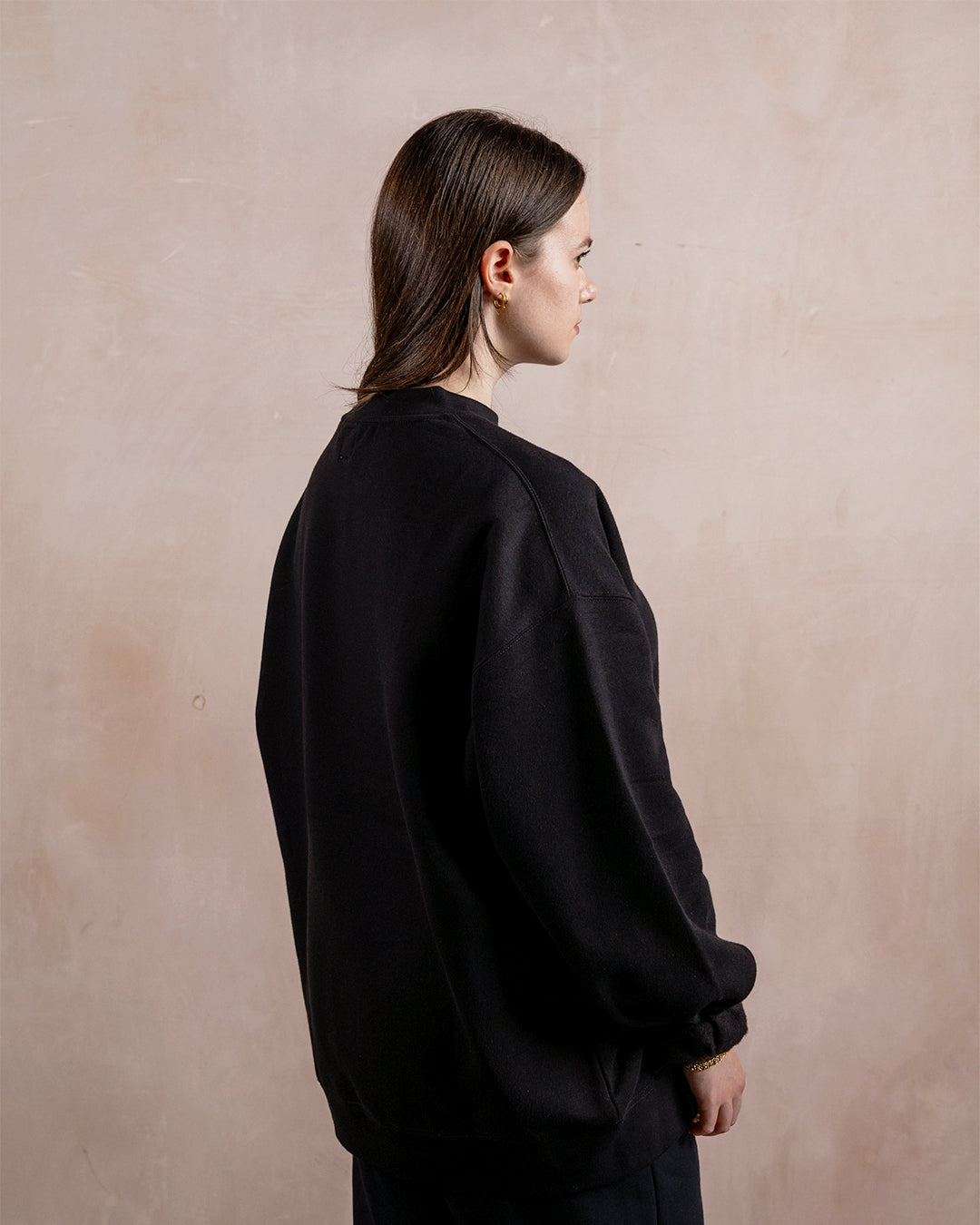 the side profile of a woman wearing a black sweatshirt
