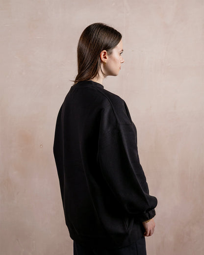 the side profile of a woman wearing a black sweatshirt