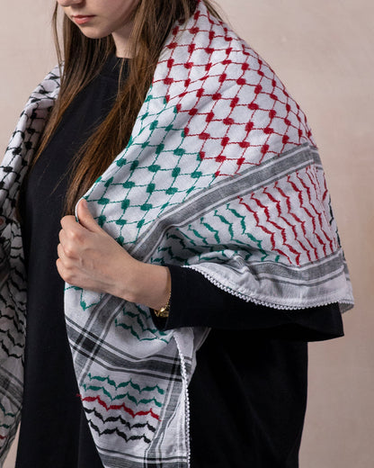 close up of a female wearing the palestinian keffiyeh in palestine flag colours