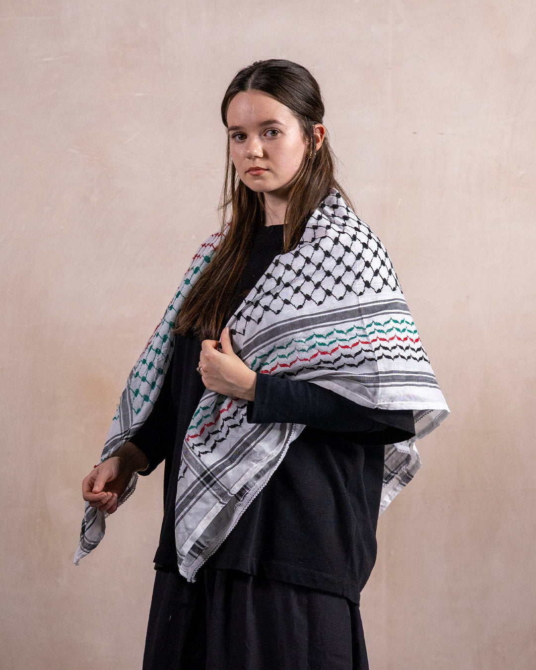 a female wearing the palestinian keffiyeh in palestine flag colours