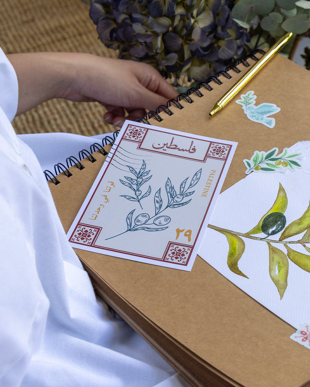 a postcard with designs inspired by palestinian culture on a scrapbook