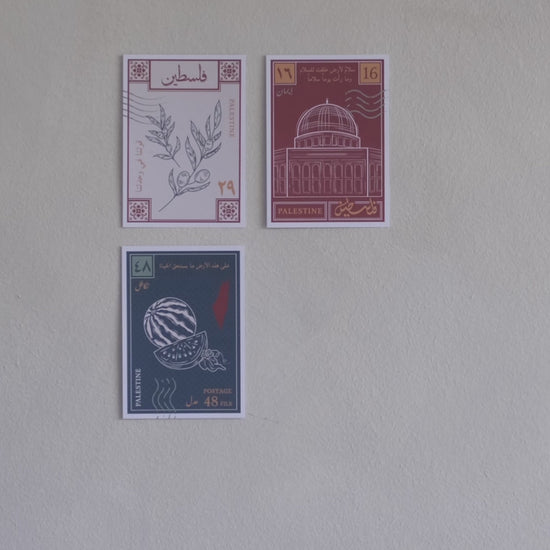 A stop motion clip of a woman sticking a fourth postcard to a wall with designs inspired by palestinian culture 