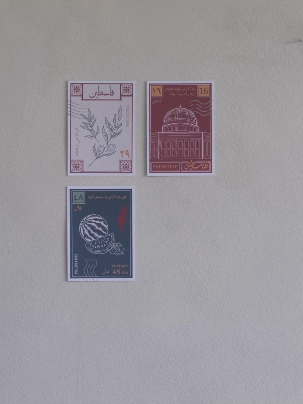 A stop motion clip of a woman sticking a fourth postcard to a wall with designs inspired by palestinian culture 