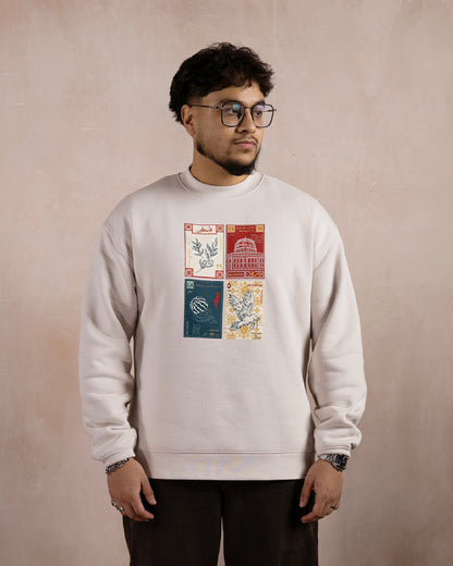 a man wearing a light beige sweatshirt printed with a design inspired by palestinian culture