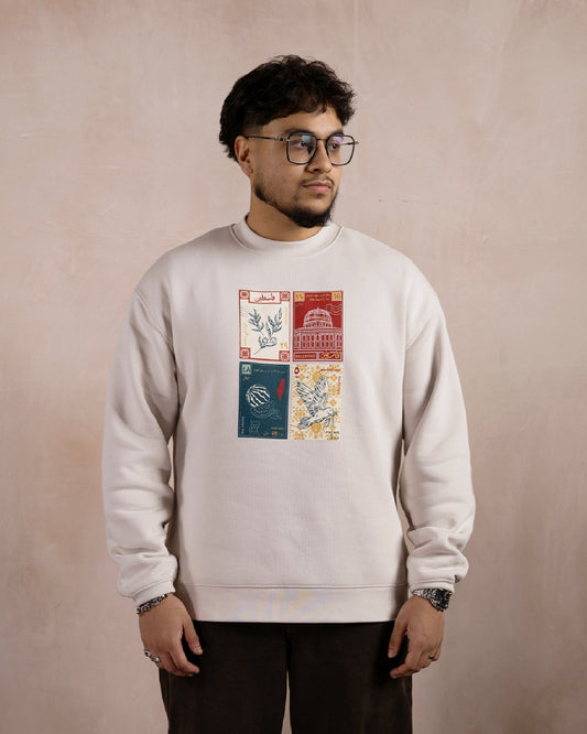 a man wearing a light beige sweatshirt printed with a design inspired by palestinian culture